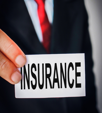 Business man showing texts of Insurance concept on paperの写真素材