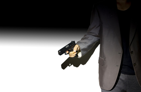 Close up male hand holding gun with dark background use for texts displayの写真素材
