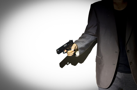 Close up male hand holding gun with dark background use for texts displayの写真素材