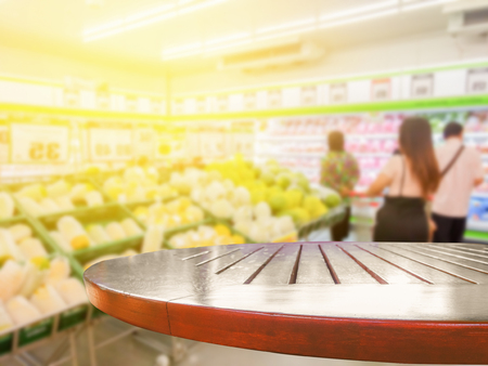 Blurred people going to shopping at department store with wooden tabletop use for products displayの写真素材