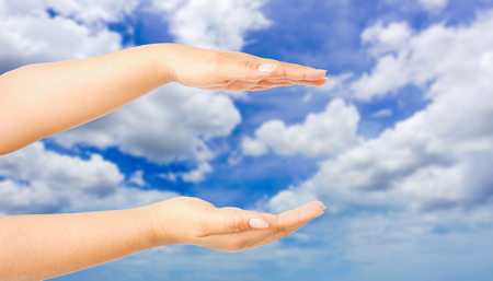 human hand showing gesture with blue sky backgroundの写真素材