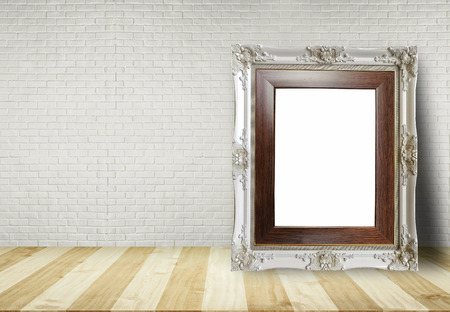 Close up blank picture frame put on table with brick wall background use for text or product displayの写真素材