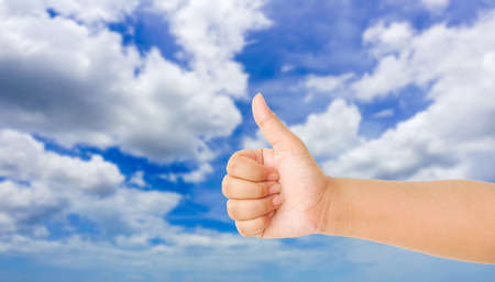 human hand showing gesture with blue sky backgroundの写真素材
