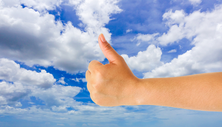 human hand showing gesture with blue sky backgroundの写真素材