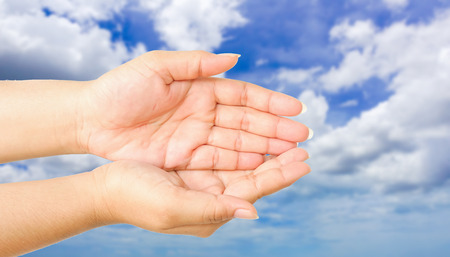 human hand showing gesture with blue sky backgroundの写真素材