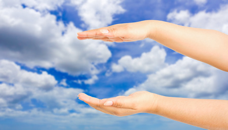 human hand showing gesture with blue sky backgroundの写真素材