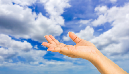 human hand showing gesture with blue sky backgroundの写真素材