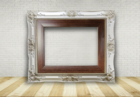 Close up blank picture frame put on table with brick wall background use for text or product displayの写真素材
