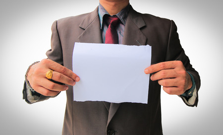 Businessman in suit showing white blank paper use for texts displayの写真素材