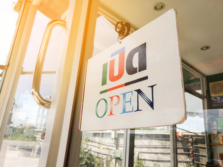 Close up open sign with sun flare at the coffee shopの写真素材