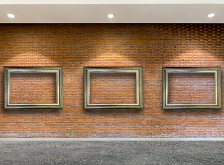 Close up wooden picture frame on red rustic brick wall backgroundの写真素材