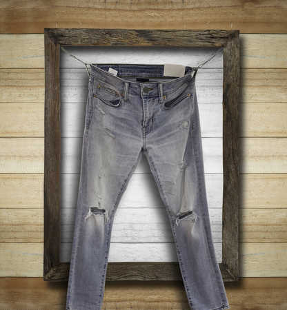 Picture of old rustick denim jeans on wooden frame backgroundの写真素材