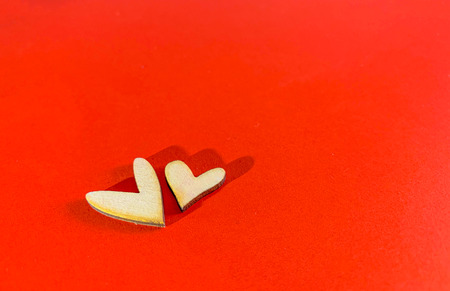 Close up brown wooden heart sign put on red paper background, Valentine's day concept.