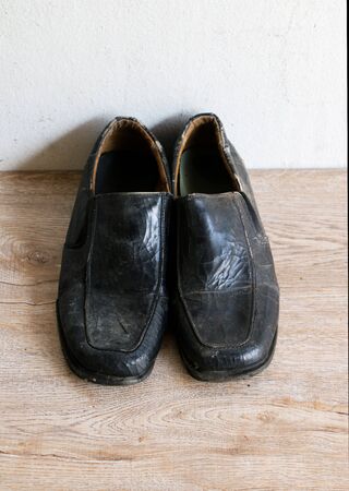 Close up retro old vintage leather shoe put on wooden table topの写真素材