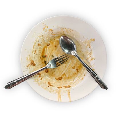 Close up top view dirty empty white dish isolated on white background with spoonの写真素材