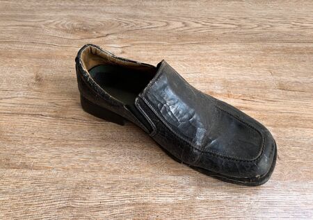 Close up retro old vintage leather shoe put on wooden table topの写真素材