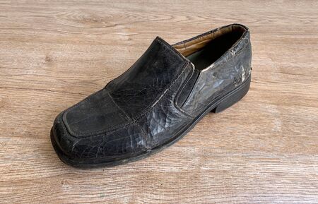 Close up retro old vintage leather shoe put on wooden table topの写真素材
