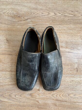 Close up retro old vintage leather shoe put on wooden table topの写真素材