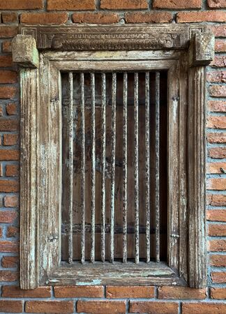 Close up grunge rustic prison window with rust brick backgroundの写真素材