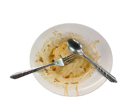 Close up dirty empty dish with spoon and fork put on tableの写真素材