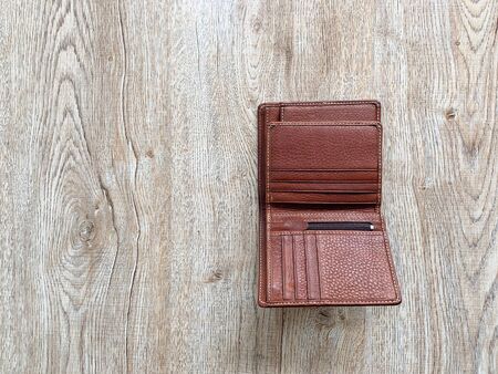 Close up brown leather luxury wallet put on wooden table backgroundの写真素材