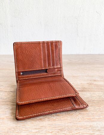 Close up brown leather luxury wallet put on wooden table backgroundの写真素材