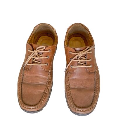 Close up old brown leather shoes isolated on white backgroundの写真素材