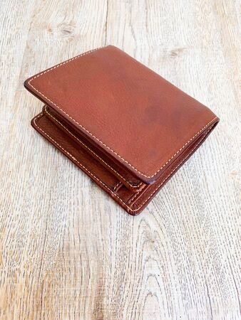Close up brown leather luxury wallet put on wooden table backgroundの写真素材