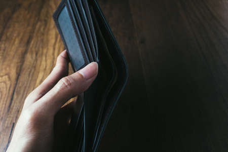 Man hand open wallet on wooden table backgroundの写真素材