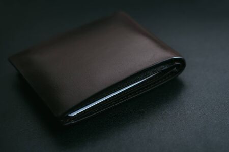 Close Up Classic dark brown leather wallet on black leather backgroundの写真素材