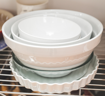 Dishes stacked on shelves in a kitchen area.の写真素材