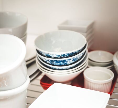 Dishes stacked on shelves in a kitchen area.の写真素材