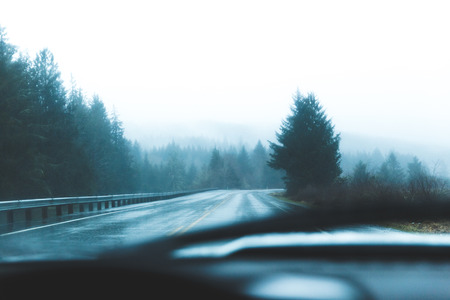 Driver's point of view on a wet, shiny road near the coast in western Oregon, USA.の写真素材