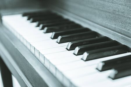 Close-up view of keys on an antique, wooden, upright piano.