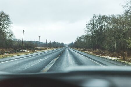 Driver's point of view on a wet, shiny road near the coast in western Oregon, USA.の写真素材