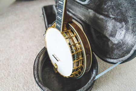 High-value banjo in custom hard case. Banjo has mahogany body and gold accents.の写真素材