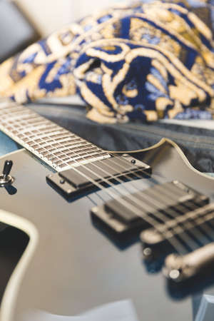 Electric guitar laying on bed.の写真素材