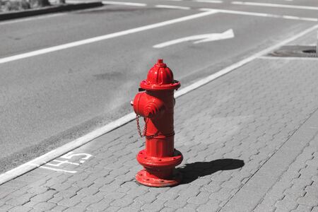 Red fire hydrant in otherwise black and white street scene.の写真素材