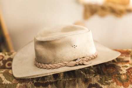 Leather cowboy hat resting on an old couch.の写真素材