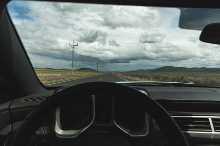 Driver perspective on highway with storm clouds above.の写真素材