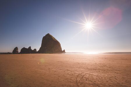 Cannon Beach's Haystack Rock at low tide in bright sunshine.の写真素材