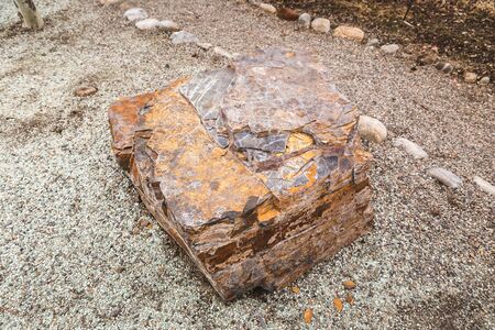 Rectangular brown and orange stone outside near a walking path.の写真素材