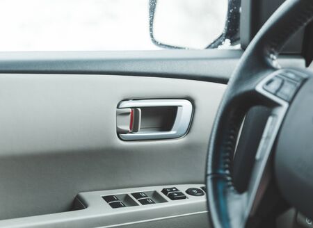 Door handle, lock, and window controls on the inside of a modern vehicle.の写真素材