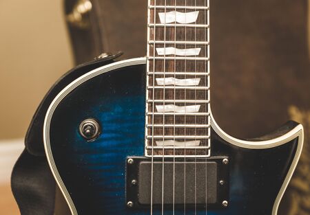 Portion of the neck and body of an electric guitar showing the strings, fretboard and pickup.の写真素材