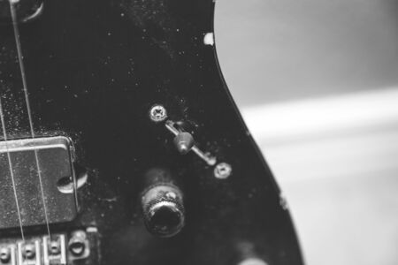 Portion of the body of an electric guitar showing the strings, pickups and knobs.の写真素材