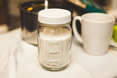Mason jar capped filled with white sugar.の写真素材