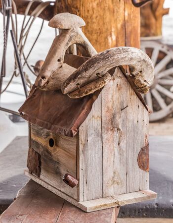 Wooden birdhouse on the porch of a log cabin.の写真素材