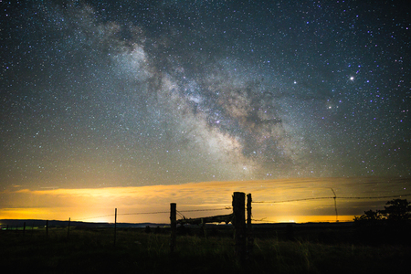 Milky Way over clouds and fence line in rural Wyoming, USA.の写真素材