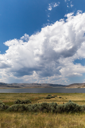 Puffy cumulus clouds in blue sky over a lake in western Montana, USA.の写真素材