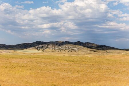 Puffy clouds cast shadows over mountains in the high desert of the western United States.の写真素材